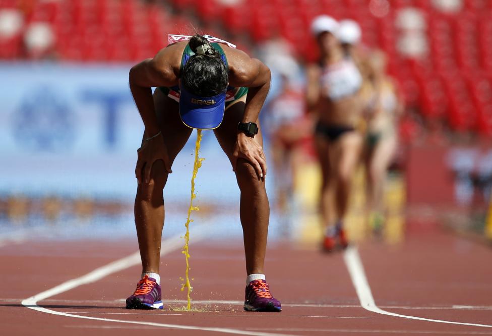 Cisiane Lopes of Brazil vomits after competing in the women's 20 km race walk final during the 15th IAAF World Championships at the National Stadium in Beijing, August 28, 2015. REUTERS/Lucy Nicholson