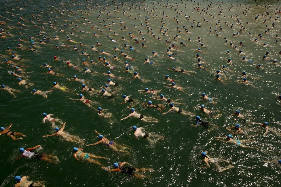People swim during the annual public Lake Zurich crossing swimming event in Zurich, July 1, 2015. The participants crossed Lake Zurich, a distance of 1,500 metres (4,921 ft). REUTERS/Arnd Wiegmann