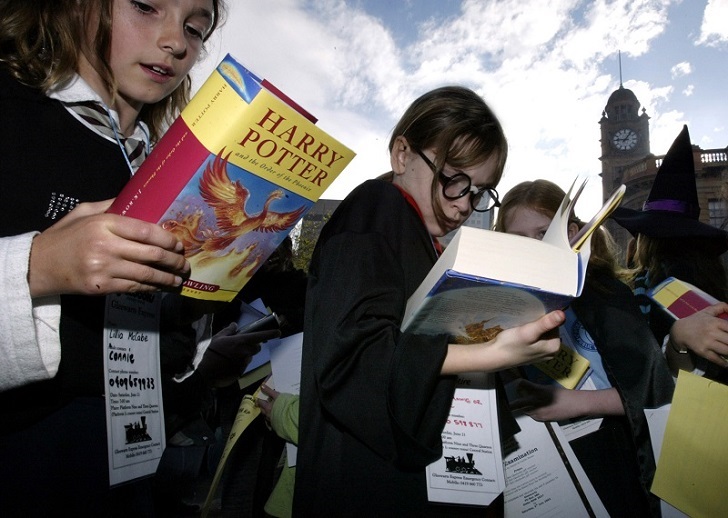 Young girls read J.K. Rowling's "Harry Potter and The Order of the Phoenix" at Sydney's Central Station June 21, 2003 after it was released in Australia. After three long years of waiting, millions of Harry Potter fans around the world finally got their hands on the latest instalment of the teenage wizard's exploits. REUTERS/David Gray PP03060060 DG/FA - RTRPLFP