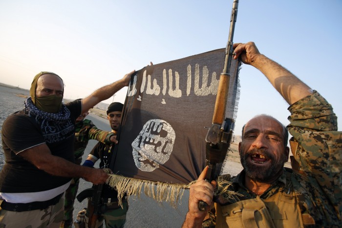 Бойцы шиитов демонстрируют трофей - захваченный флаг "Исламского государства"