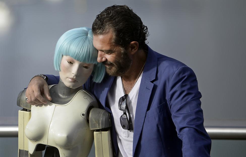 Spanish actor Antonio Banderas embraces a robot used in the film Automata at the 62nd San Sebastian Film Festival in Spain September 21, 2014. REUTERS/Vincent West