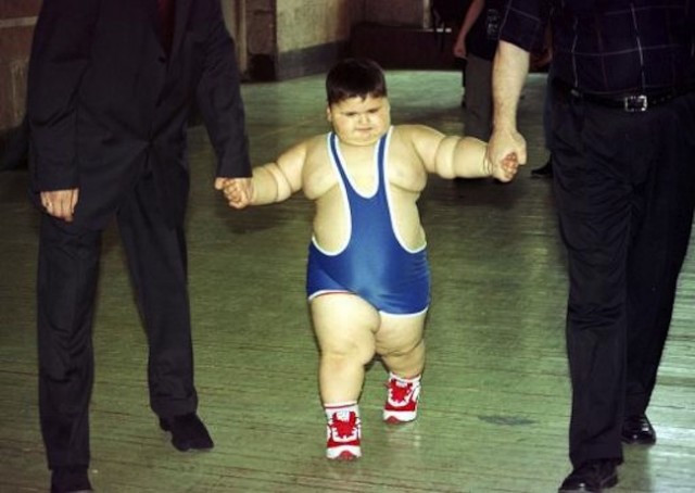 Young wrestler Dzhambulat Khotokhov, a 4-year-old Russian weighing 56 kilograms (123 pounds) with a height of 118 centimeters (3 feet 11 inches) is escorted to wrestle against Georgy Bibilauri, a Georgian, who turned 5 on Wednesday, 120 centimeters (4 feet) tall and weighs 51 kilograms (112 pounds), Tbilisi, Wednesday, July 9, 2003. Wrestlers Georgy Bibilauri and Dzhambulat Khotokhov had both hoped for victory, but they settled for ice cream instead. After the boys tied on the mat, they went off to celebrate Bibilauri's birthday with ice cream and chocolate. (AP Photo/ Shakh Aivazov)