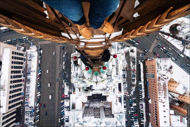 Moscow. VERTIGO inducing pictures from the top of a 155-foot-high crane have been captured by a photographer in bid to overcome his fear of heights. The amazing aerial images show the photographer and his friends throw caution to the wind as they precariously perch high above the cities with no safety equipment. Other shots capture the adventurous bunch in the middle of climbs up cranes and beautiful women posing on the edge of roof tops. The extreme photos were taken by Moscow photographer and acrophobic George Lanchevsky (24) in cities around the world including Moscow, Galich and Hong Kong.